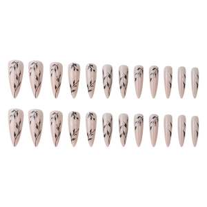 Long almond press-on nails with nude pink base and minimalist black leaf patterns