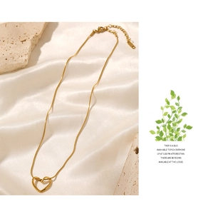 Detail of gold hollow heart necklace with adjustable clasp and elegant branding tag