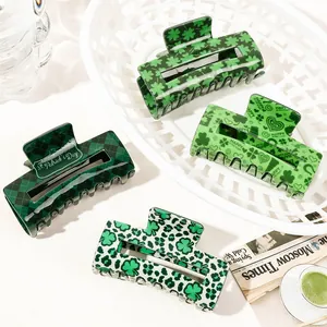 Detail of four green St. Patrick's Day hair claws with shamrock and checkerboard patterns