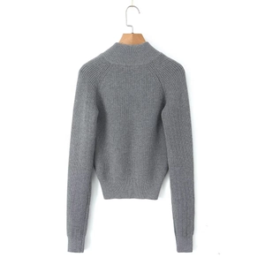 Detailed close-up of grey ribbed knit cardigan texture on a wooden hanger