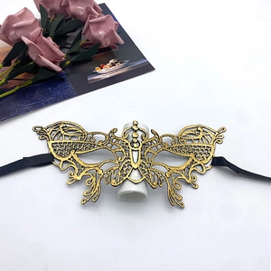 Detailed close-up of gold lace masquerade mask with black satin ribbon ties for parties