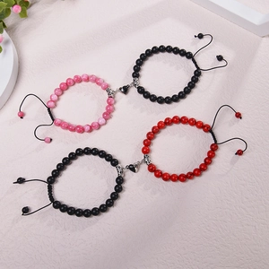 Detail of magnetic heart charms on natural stone couple bracelets with adjustable cords