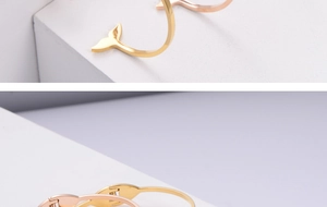Close-up of polished gold and rose gold fishtail bangles with a hinged open design