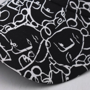 Detail of white abstract graffiti print on black fabric baseball cap with stitching