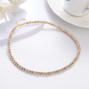 Macro shot of tricolor metallic beaded necklace with lobster clasp on white background