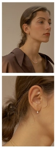 Detailed view of pear-shaped drop earrings and a layered pearl necklace set on a model