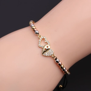 Close-up of heart and star charms on beaded adjustable bracelet worn by a model