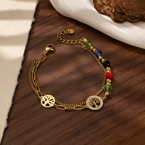 Detail of gold layered chain bracelet with colorful beads and Tree of Life charms