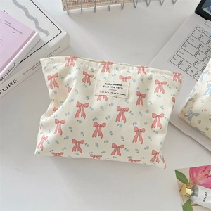 Detalle de la textura de bolsa de maquillaje floral con lazos rosas en escena de mesa