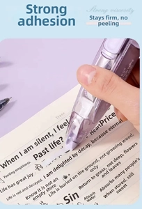 Close-up of a purple 6M retractable correction tape being used on a notebook