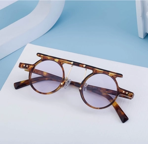 Detail of retro punk sunglasses with tortoiseshell frame and purple lenses