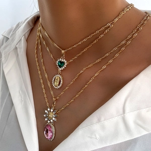 Collana dorata multistrato con cuore verde, moneta e ciondolo a goccia rosa acceso