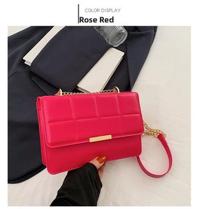 Detail of rose red quilted crossbody bag with gold metal buckle and chain strap