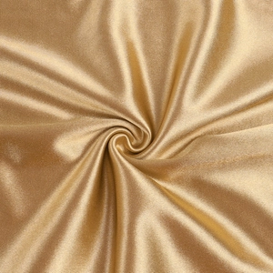 Macro shot of shiny gold metallic fabric with elegant folds and silky texture