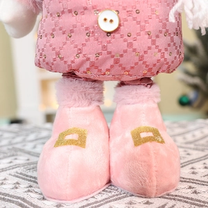 Detail of pink sequin fabric and soft plush boots on a festive holiday doll ornament