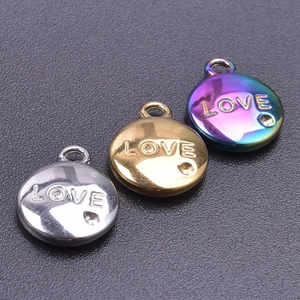 Macro shot of circular LOVE charms in silver, gold and rainbow stainless steel finishes