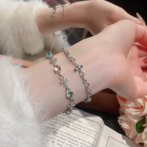 Detailed view of silver cross bracelets with colorful gemstones on a female wrist
