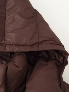 Gros plan d'une veste matelassée marron à capuche avec détails en nylon lisse