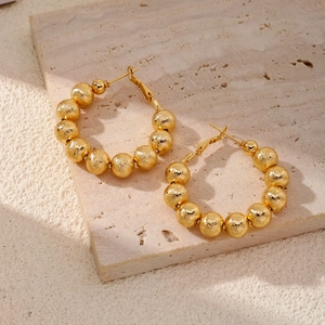 Élégantes boucles d'oreilles créoles à billes dorées avec une finition texturée chic