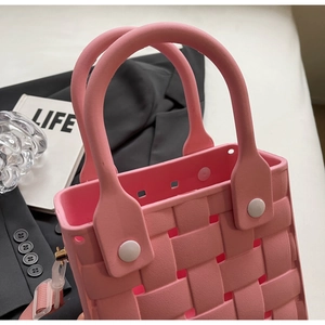 Close-up of pink EVA beach bag with woven texture and white fastening button details