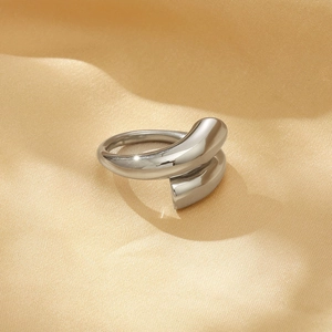 Macro shot of silver adjustable open ring on elegant gold pleated satin fabric
