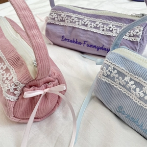 Detail der Cord-Textur mit Spitze, Schleifen und Stickerei auf großen Federmäppchen