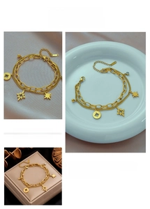 Detail view of double-layer gold star bracelet with hexagram charms and lobster clasp