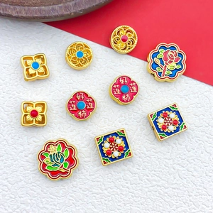 Nahaufnahme von Emaille-Blumenperlen und Sandgold-Anhängern für DIY-Schmuck