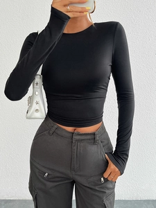 Detail view of a slim-fit black long-sleeve knit top with a classic crew neck design