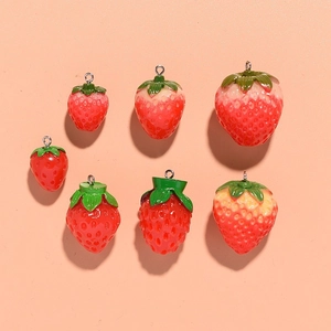 Detailed view of varied size resin strawberry pendants with green leaves and metal rings