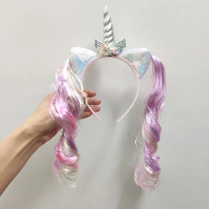 Close-up of unicorn headband with silver horn, sequin ears and long curly rainbow wig