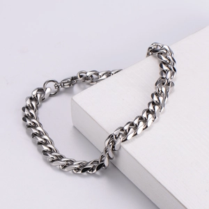 Polished silver stainless steel 7mm Cuban link bracelet for men on a white display