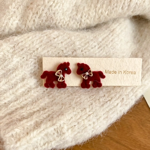 Detail of red flocked pony earrings with golden bow on Made in Korea card