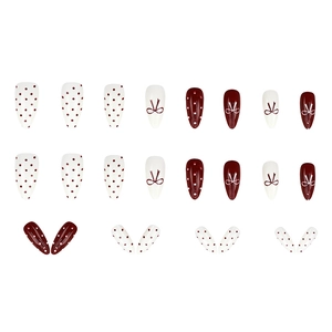 Faux ongles bordeaux et blancs à pois avec motifs de nœuds, forme stiletto longue