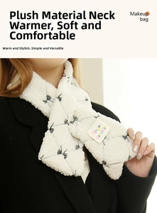 Detailed close-up of a white plush scarf with black bow patterns and a decorative brand tag