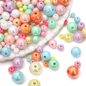 Close-up of colorful mixed acrylic round beads on a wavy white tray for DIY jewelry making
