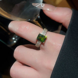 Detail of 18k gold plated ring with emerald green zircon and pave diamonds on hand