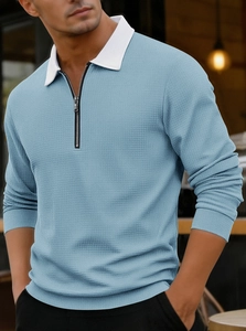 Close-up of light blue waffle knit fabric with white contrast collar and zipper detail