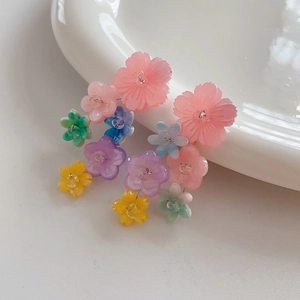 Close-up of colorful resin flower earrings with delicate tassel details and vibrant petals