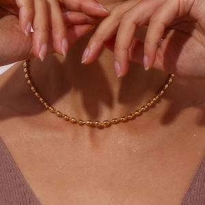Close-up of minimalist 18K gold plated stainless steel oval bead chain necklace on model