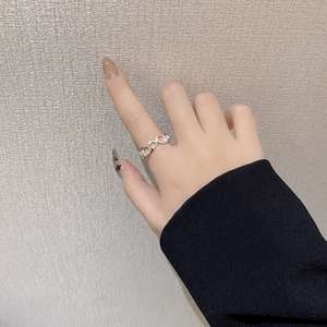 Close-up of S925 sterling silver pig nose chain ring worn on a finger with soft lighting
