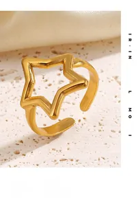 Close-up of gold plated hollow star ring with a brushed metal texture and open design