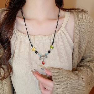 Detail of beaded necklace with red persimmon charm and Fu character silver pendant