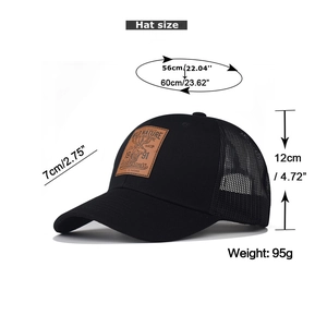 Detail of black mesh trucker hat featuring a brown leather patch with a reindeer motif