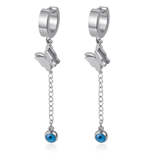 Detail of silver steel hoop earrings with butterfly charms and blue evil eye bead tassels