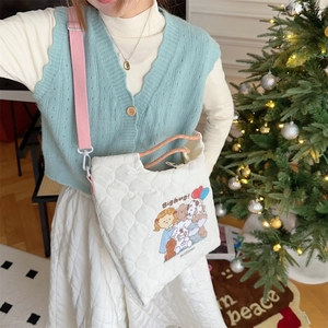 Detail of white quilted crossbody bag with cute embroidery and pink shoulder strap
