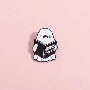 Cartoon ghost enamel pin holding Human Stories book on a soft pink background