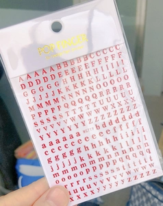 Detail of red 3D English letter nail stickers WG719 in transparent plastic packaging