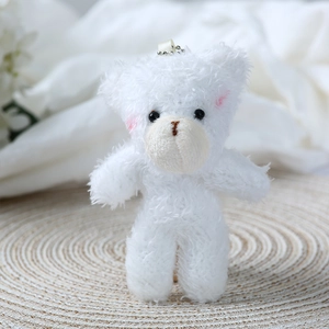 Close-up of white plush bear pendant with soft fur texture and pink blush cheeks detail