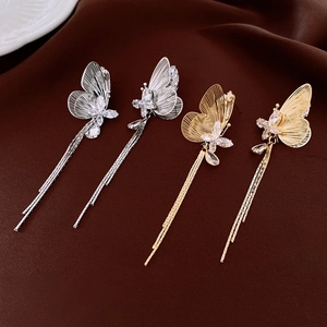 Dettaglio di orecchini a farfalla con nappe placcati oro 18k e zirconi scintillanti